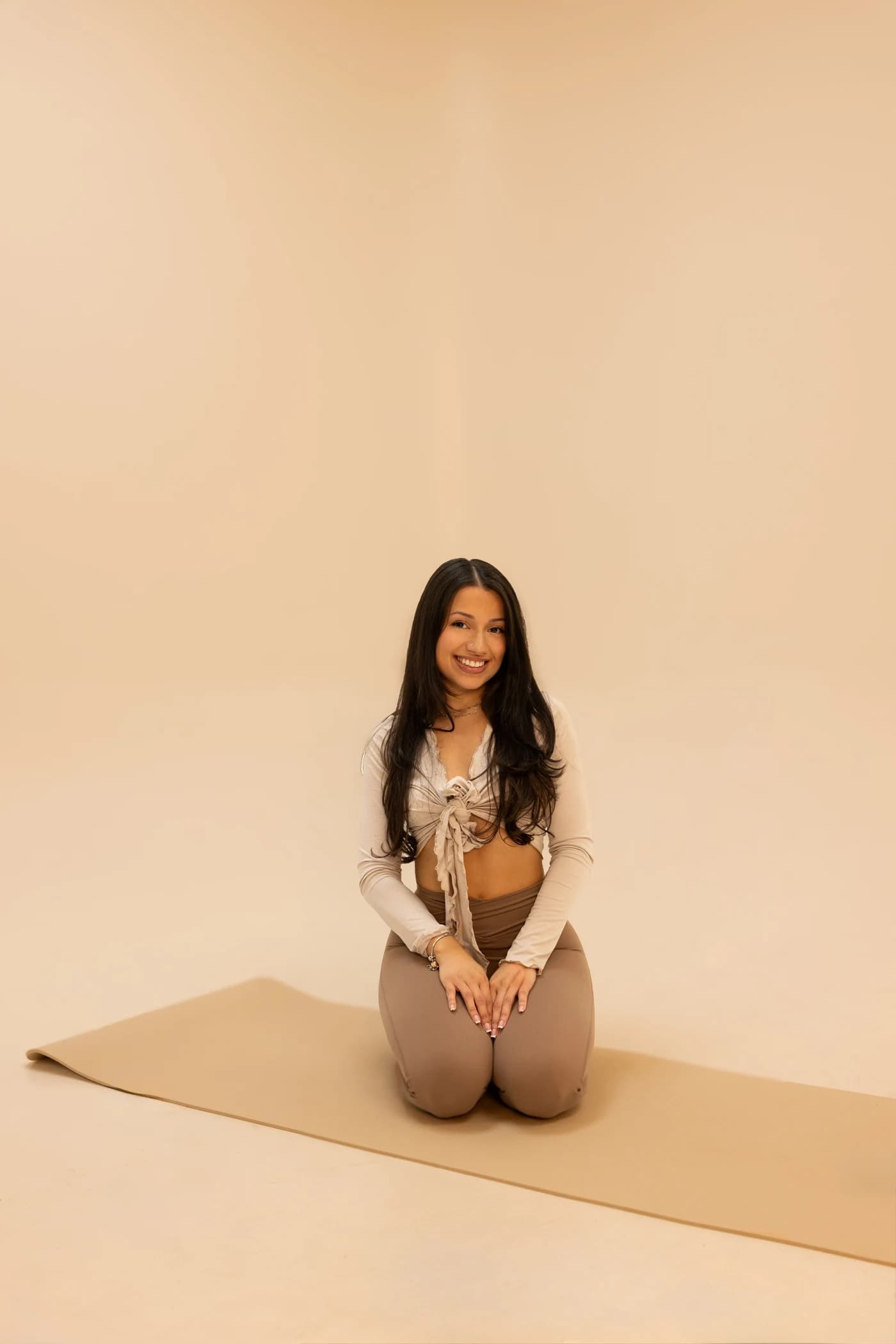 Denise smiling while seated on her mat
